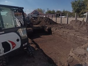 Bobcat gép alapgödör mellett földmunkavégzés közben